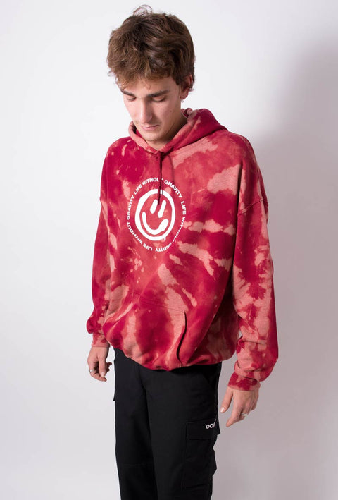  felpa rossa con cappuccio con tintura effetto tie dye che disegna una spirale di colore più chiaro davanti, al centro stampato in bianco uno smile contornato dalla scritta 