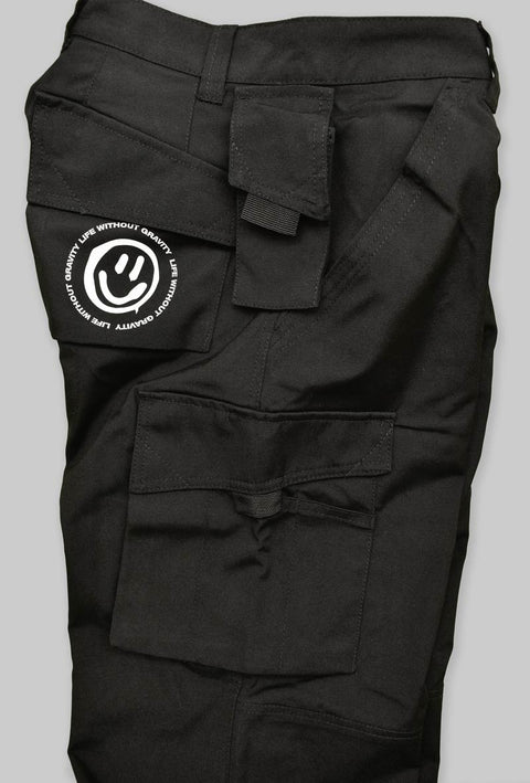  pantalone nero modello da lavoro in teflon con tasche sulle cosce e sul lato con stampato il logo taboo sulla tasca laterale. Visione laterale